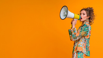 Announcing Discounts Sale. Young woman with Megaphone in Fashion Model Shopping Concept. Orange Studio Isolated Background with Copy Space