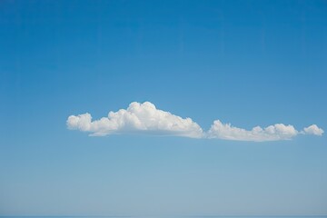 A clear blue sky with a solitary white cloud - obrazy, fototapety, plakaty