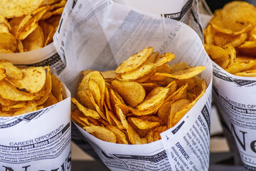 Fried potato wedges in a paper bag. Street food concept.