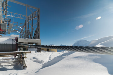 A cable car station high in the mountains under construction. Snowy mountain landscape and construction of a metal structure for a cable car