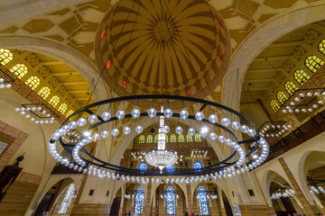 Interior view of the dome, ceiling and large hanging light fixture chandelier inside the Al Fateh...