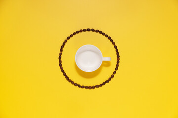Empty coffee cup and coffee beans on yellow background