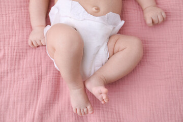 Little baby in diaper on bed, closeup
