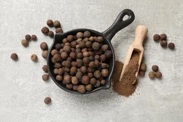 Fototapeten Ground allspice pepper, grains and scoop on grey table, flat lay © New Africa