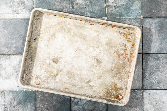 Overhead of old baking sheet on tile