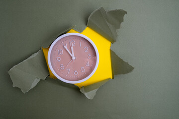 White alarm clock on a colored background. Fashionable minimalist style. Time, business and technology concept. Flat composition. View from above