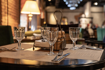 A served table in café or restaurant .Glasses, forks, knives served for dinner in restaurant with...
