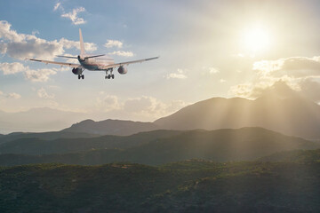 Airplane flying over the mountains at sunset. Travel concept.