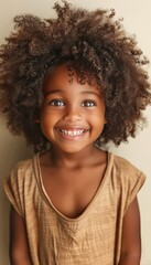 Happy curly haired child smiling and making eye contact with camera for a charming portrait