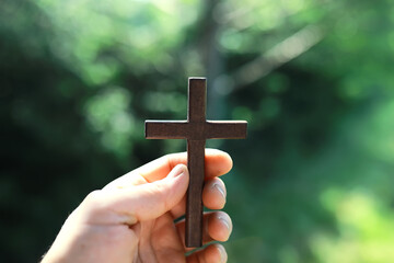 Concept conceptual black cross religion symbol silhouette in grass