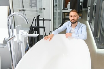 Young man choosing a bath and bath sink