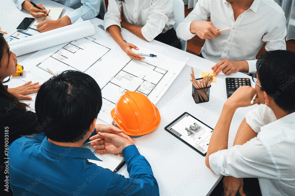 Poster Diverse group of civil engineer and client working together on architectural project, reviewing construction plan and building blueprint using tablet at meeting table. Prudent