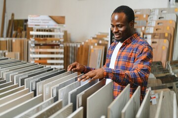 African american man customer choosing ceramic tile at building materials store