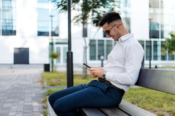 Man Sitting on Bench Using Cell Phone