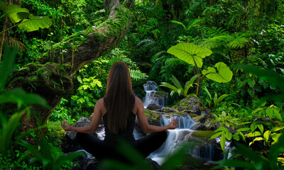 Woman doing yoga in front of rainforest