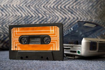 Audio casette near a walkman. Retro music devices. Vintage audio tape. 