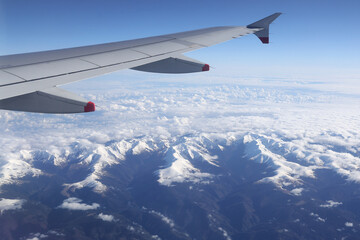 Airplane flying above the Fagaras mountains covered with snow. Photo taken through the airplane window.