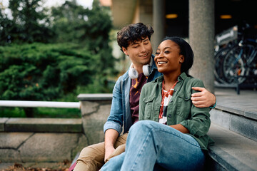 Happy university couple relaxing outdoors at campus.