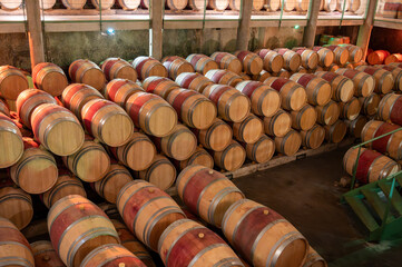 French oak wooden barrels for aging red wine in underground cellar, Saint-Emilion wine making...