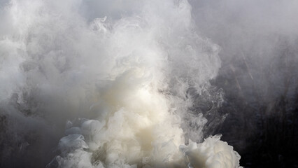 Texture of smoke of gray and white colors in sunlight