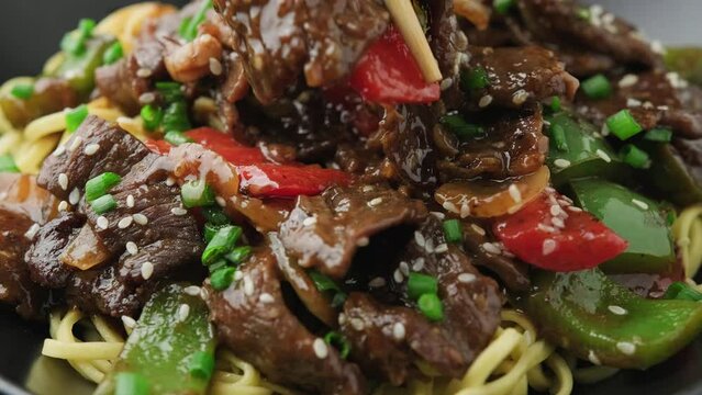 Eating Beef in black bean sauce with vegetables and noodles. take away food.