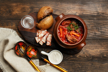 Traditional Russian and Ukrainian beet soup borsch with beef and mushrooms in clay pot served with...