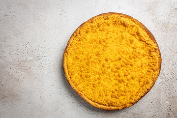 Dutch 'Kruimelvlaai' on a rustic, beige stone table. Top view of a dutch pie. 