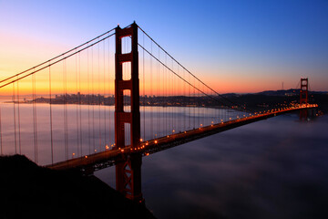 lighted golden gate bridge at dawn with beautiful clear sky