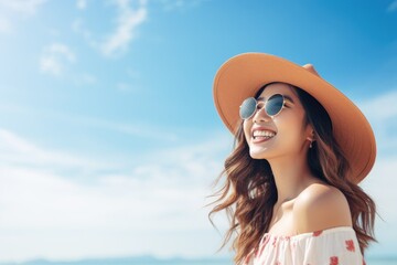 Beautiful Happy young Asian tourist woman wearing a beach hat, and sunglasses, going to travel on holiday on a blue sky background. travel concept.