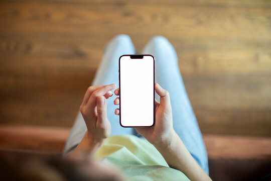 Top view of woman holding smartphone with blank screen