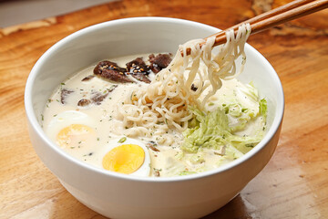 Japanese ramen noodle soup, with a combination of a rich flavored broth, one of a variety of types of noodle and a selection of meat and vegetables, often topped with a boiled egg.
