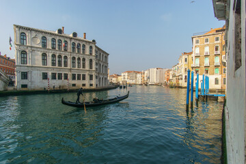 A gondola boat on the Canal Grande on a sunny winter day in front of typical building facades,...