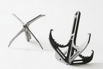 Two iron professional climbing assault hooks for industrial mountaineering and rock climbing. White background. Photo. Selective focusing