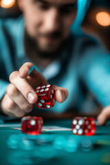 Focused man rolling red dice on a game table, capturing a moment of suspense and risk in gaming, and addictions and bad habits.