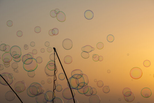 Lots of soap bubbles in the sky at sunset with soap bubble stick
