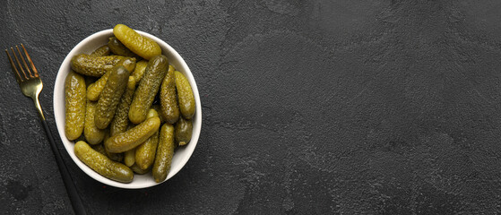Bowl of tasty pickled cucumbers on dark background with space for text, top view