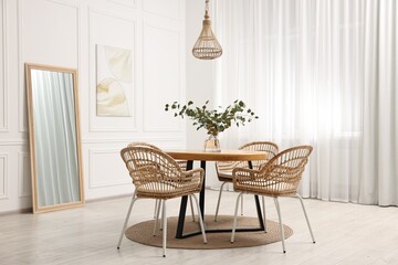 Dining room interior with comfortable furniture and eucalyptus branches