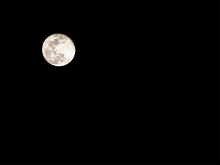 A full moon glows against a black sky