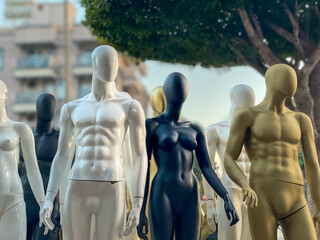 Mannequins in varying shades and finishes stand in a line, creating a striking visual for retail or...