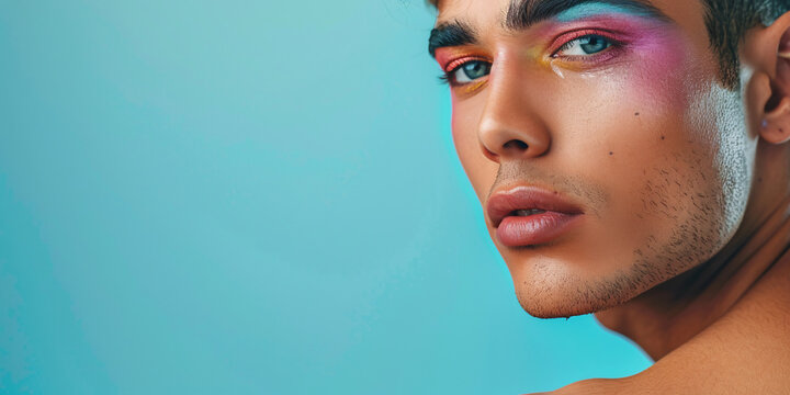 Portrait of gay man with make up on the blue