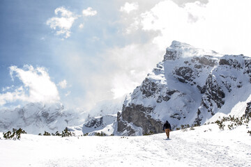 samotny wędrowiec na tle skalistego szczytu w górach zimą, Kościelec, Tatry