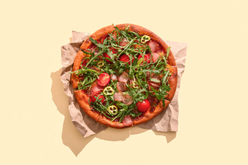 Delicious pizza with tomatoes and arugula on yellow background