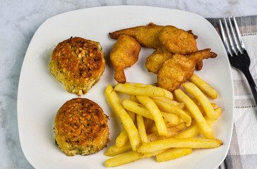 two crab cakes with  fries and beer batter shrimp