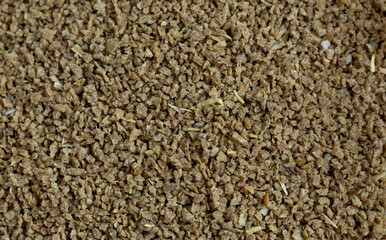 Dry Daphnia fish feed flakes background. Top view
