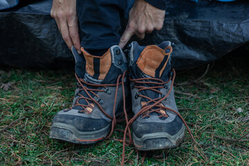 Closeup of Man Wearing Dirty Trekking Boots on Grass