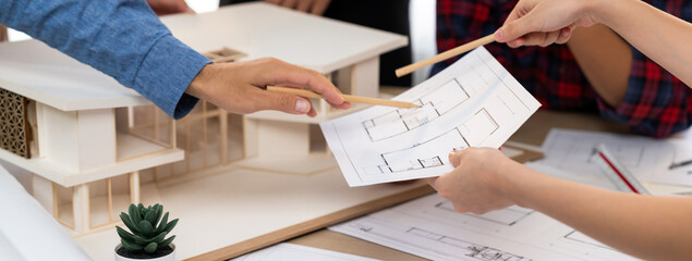 Architect team analysis and brainstorming about house construction at meeting table with house...