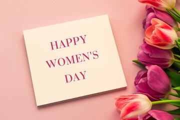 Happy Women's Day inscription, greeting card with tulips on a pink background