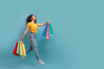 Joyful woman shopping on blue