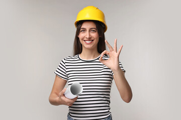 Architect with hard hat and draft showing ok gesture on light grey background