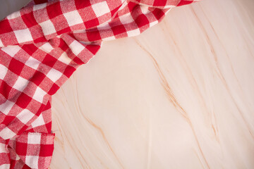 Pink marble table with red and white checkered napkin around, space for text or branding